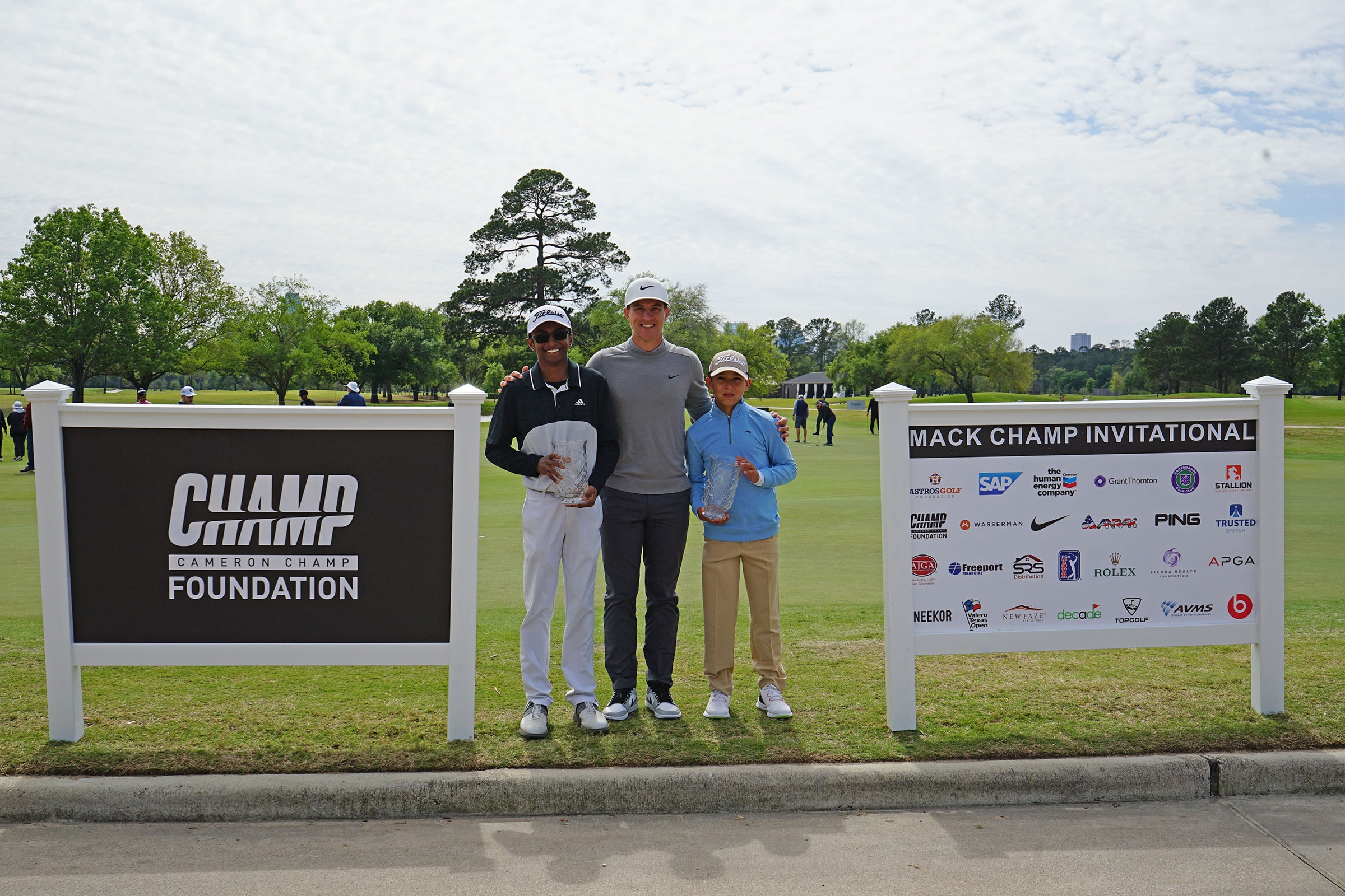 Shiv Parmar, Cameron Champ and Isaiah Diaz with foundation and sponsor signs